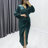 فستان سهرة من الساتان باللون الأخضر الزمردي بياقة متقاطعة وأكمام بالون منسدلة