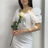 فستان بأكمام قصيرة مزين بتفاصيل لؤلؤية بيضاء، بأكمام أميرة وقصة قلم رصاص.